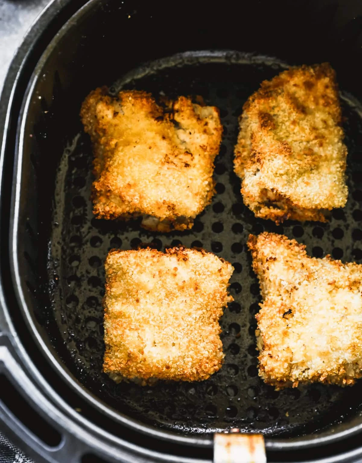air fryer basket lined with fish