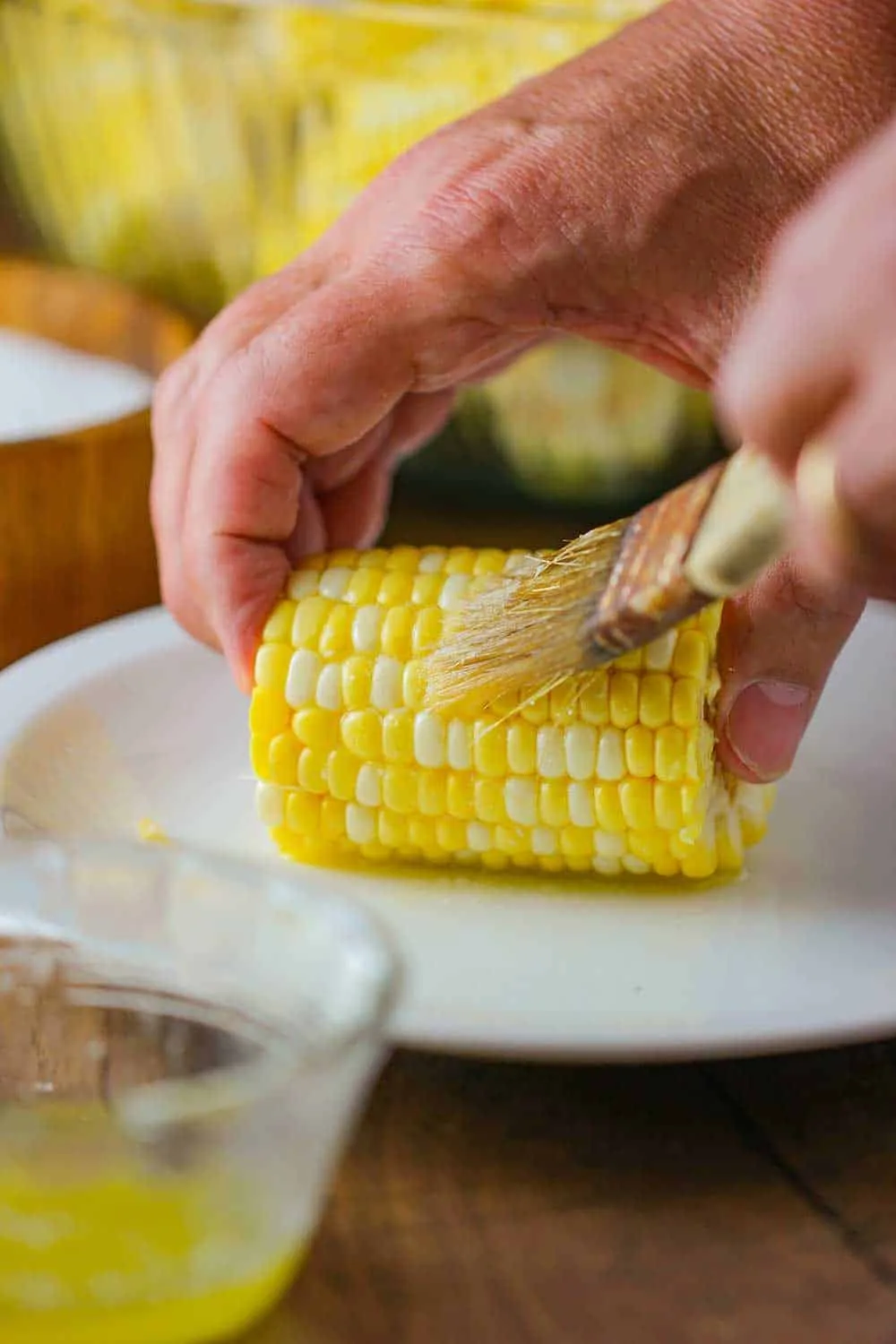 brushing butter on corn ribs