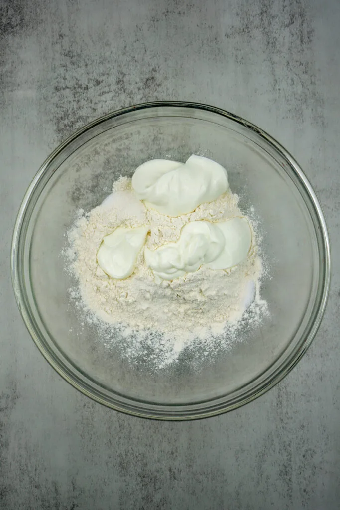 Greek yogurt and self rising flour in mixing bowl