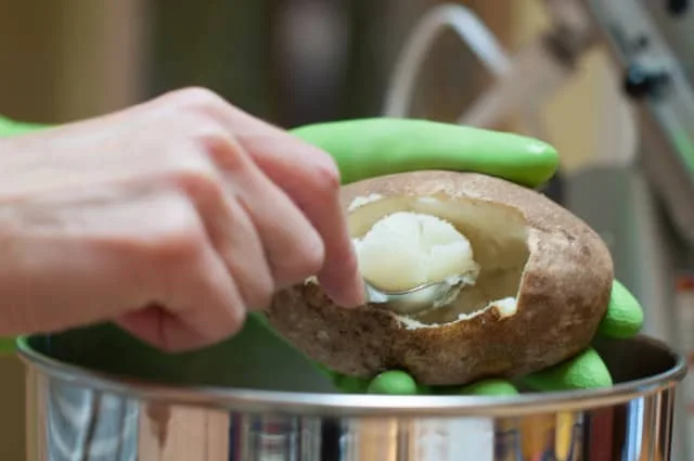 scooping baked potato flesh